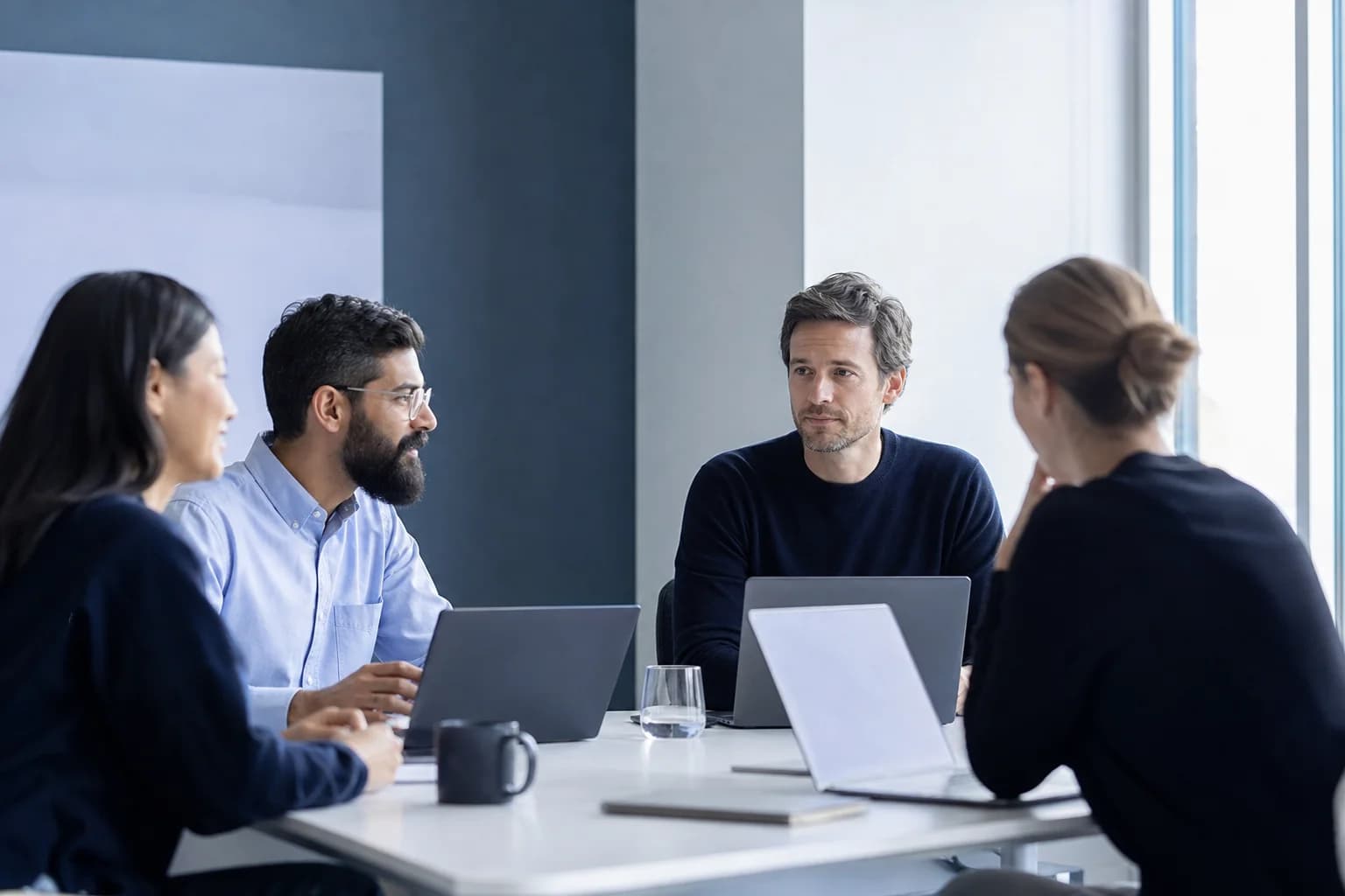 Engineering leaders comparing remote developer candidates in a modern workspace